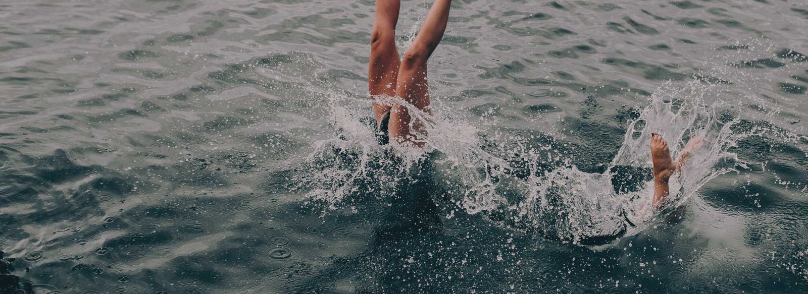 Two woman jumping into the lake. kelowna boat charters, kelowna boating rentals