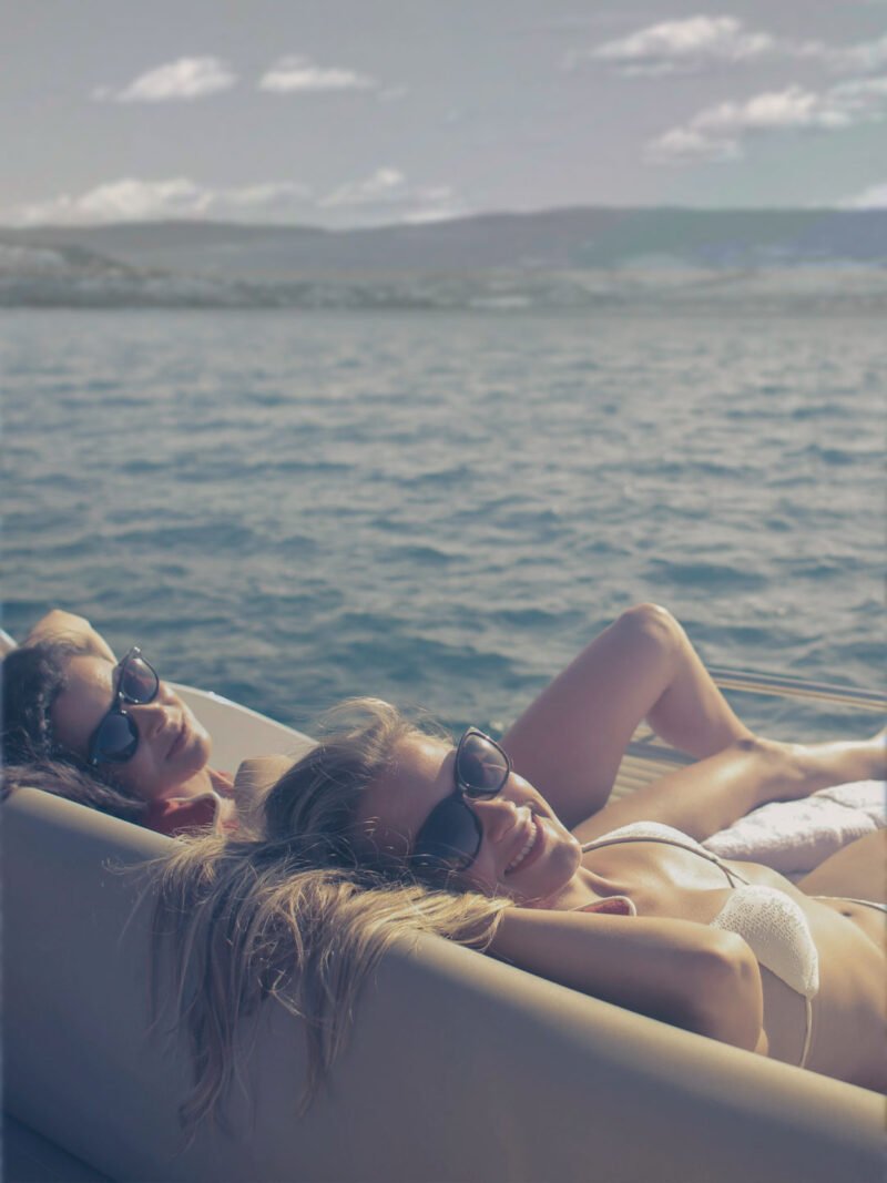 Two woman relaxing on Okanara boat near Peachland. kelowna lake tour