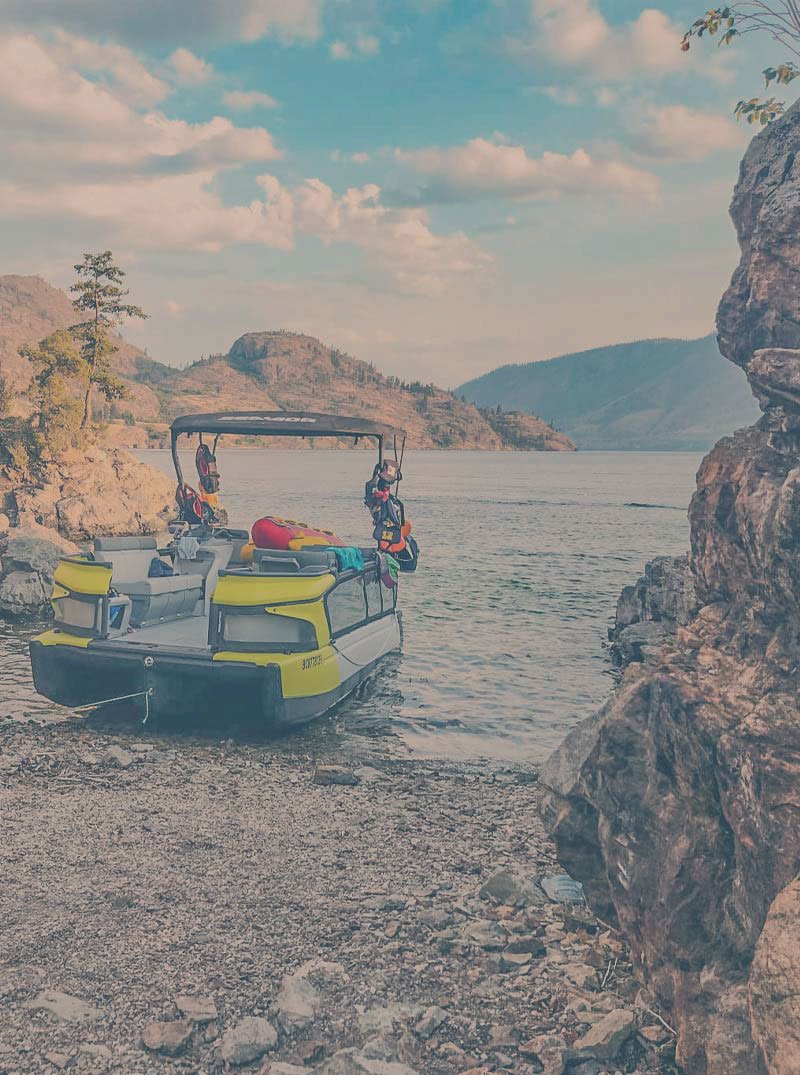 Okanara boat docked on the beach. boat rentals kelowna