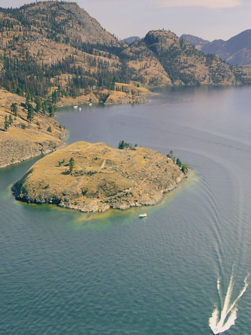 Drone view of Rattlesnake Island with Okanara boat on the lake.