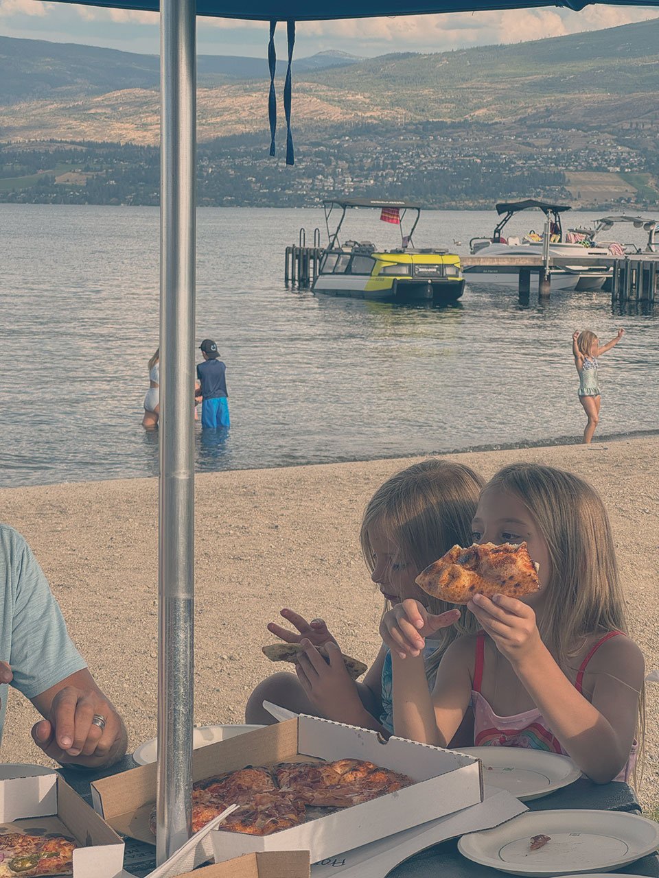 Family enjoying food at a beach winery / restaurant.