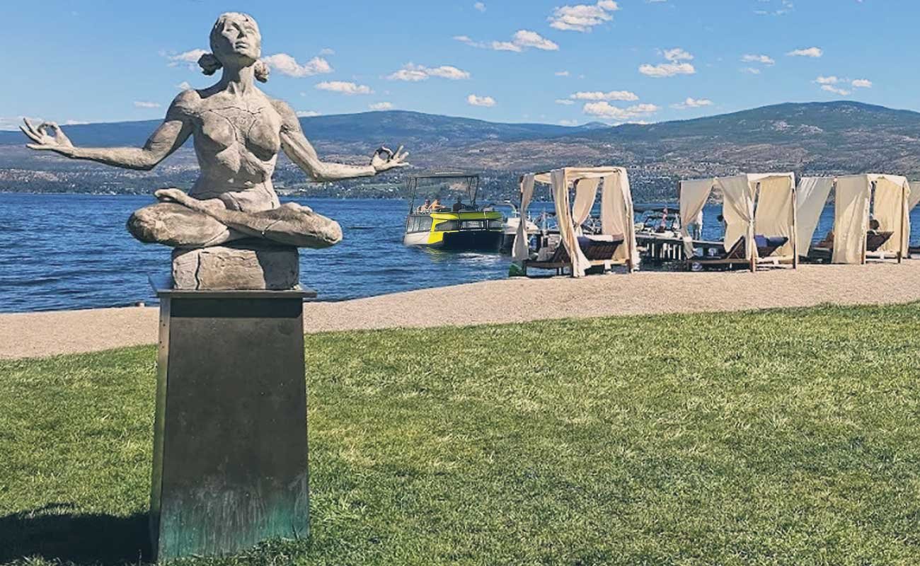 Sculpture of a meditating woman on the beach at Frind Wine Estates with Okanara boat docked in the background. kelowna boat tour
