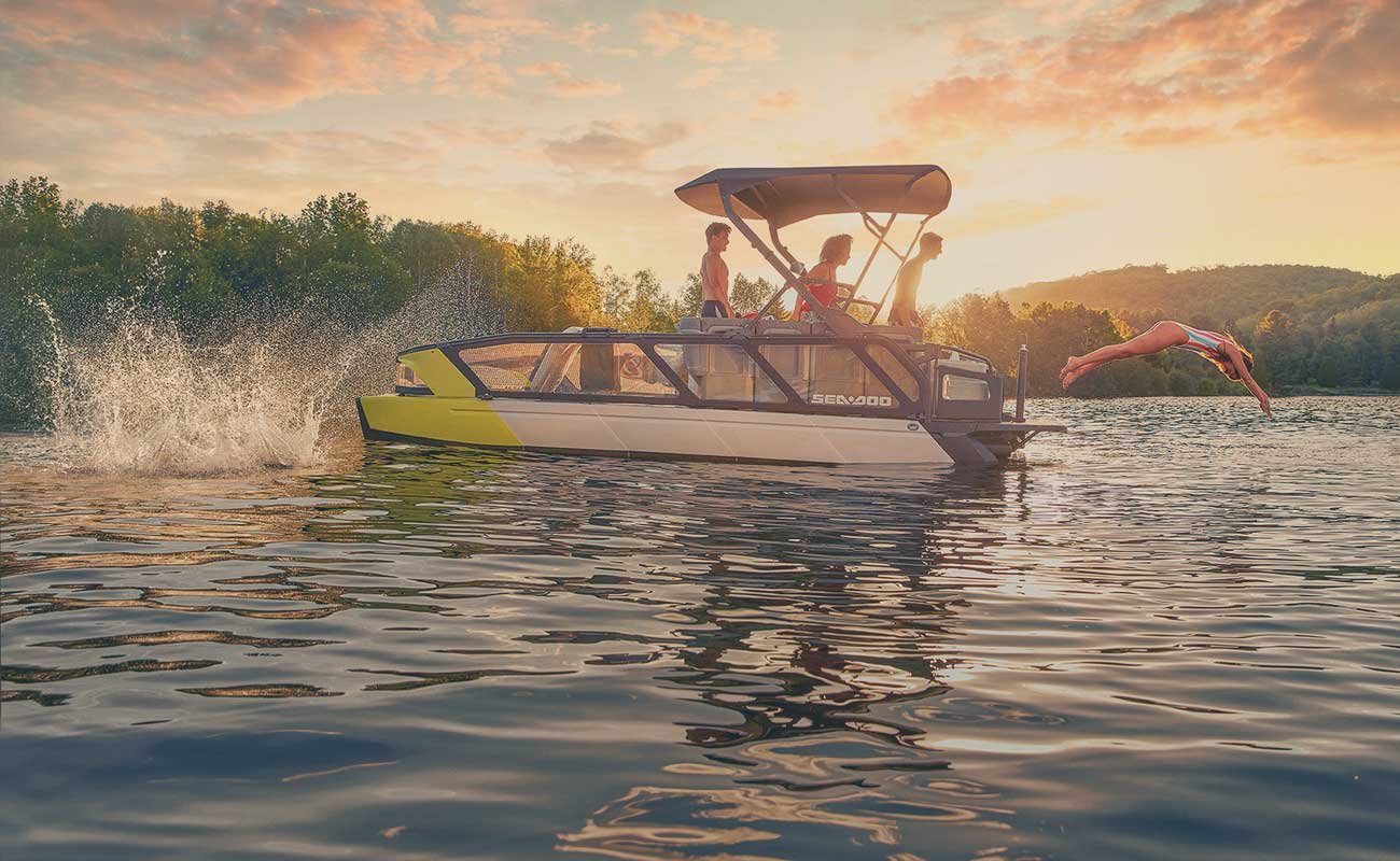 Okanara boat on the lake with guests jumping into the water at sunset. kelowna boat tour
