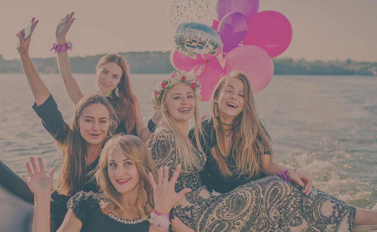 Bride and maids posing on the boat with colourful balloons in the background. kelowna boat tour