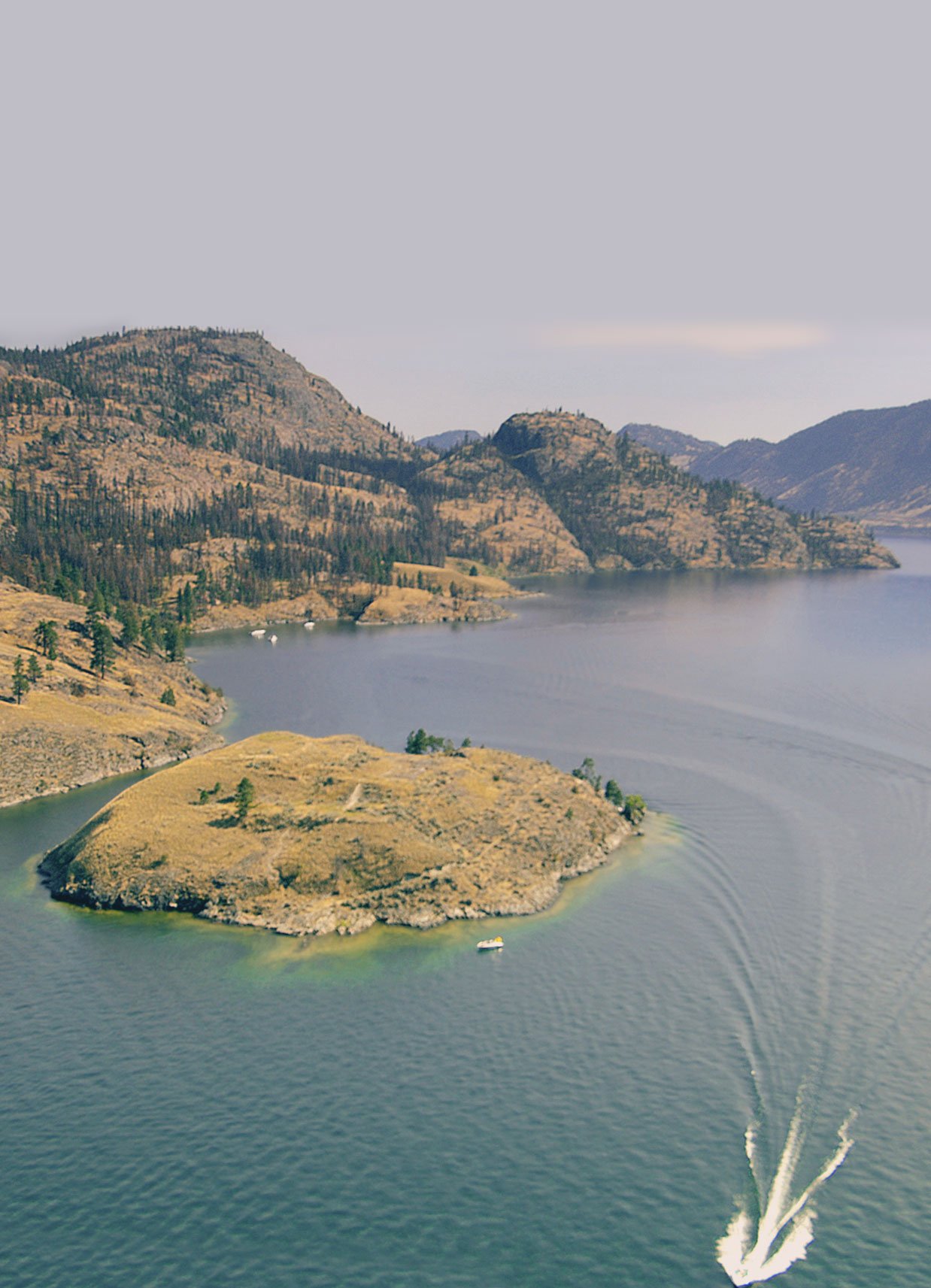 Drone view of Rattlesnake Island with Okanara boat on the lake. rattlesnake island