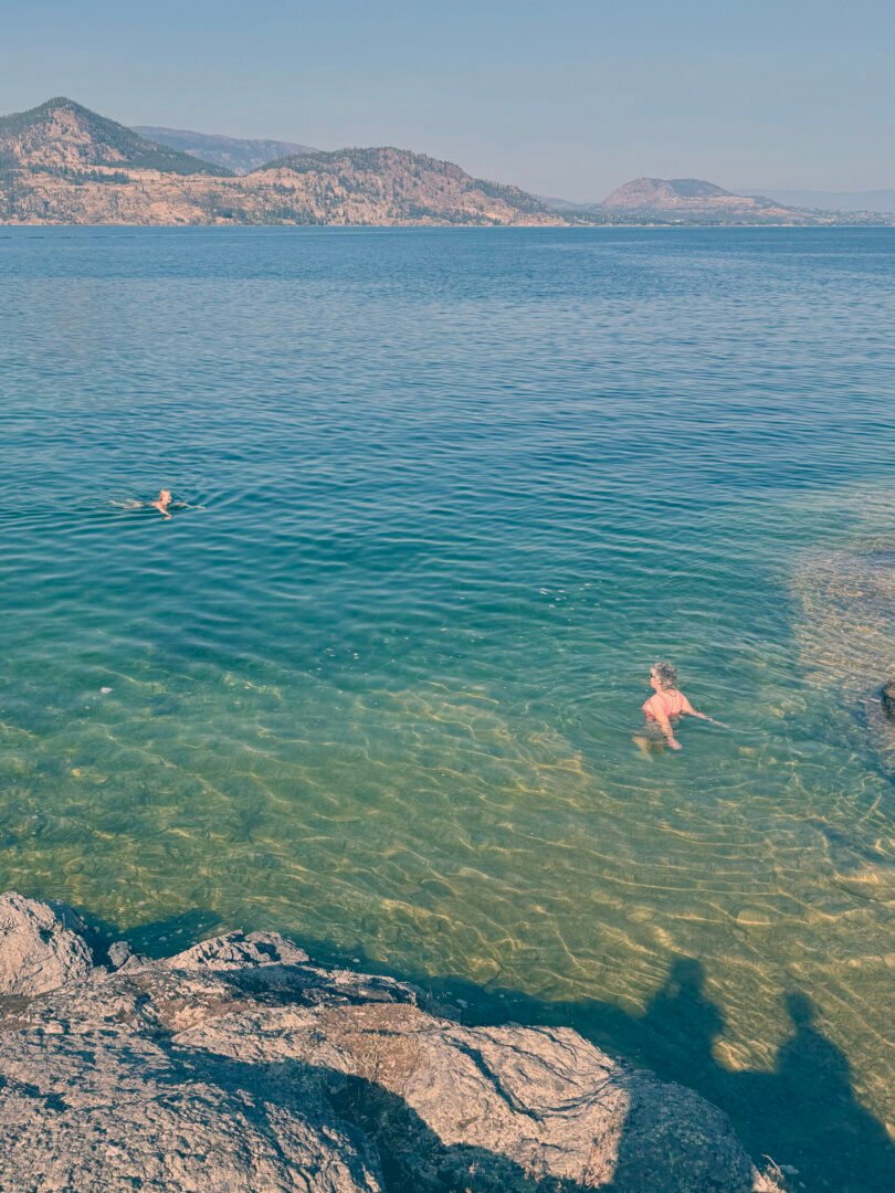 okanara guests swimming in a private cove beach on the okanagan lake. kelowna lake tour